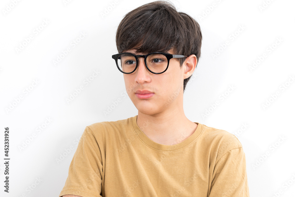 Fototapeta premium Handsome teen boy with glasses in casual brown t-shirt isolated on white background.