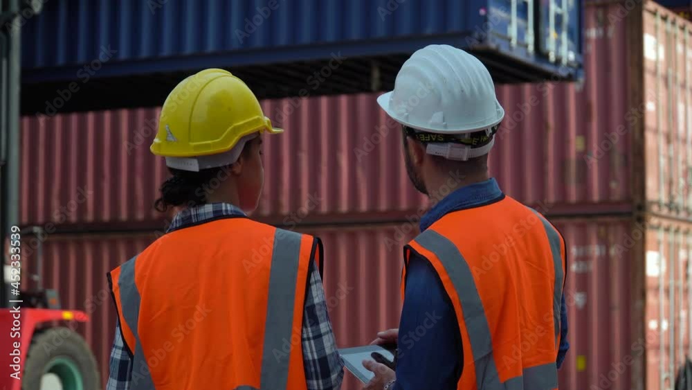 foreman and harbor worker woman using digital tablet control forklift moving up Containers box to checking list inventory loading at warehouse logistic in Cargo . import export shipping business foreman and harbor worker woman using digital tablet control forklift moving up Containers box to checking list inventory loading at warehouse logistic in Cargo . import export shipping business