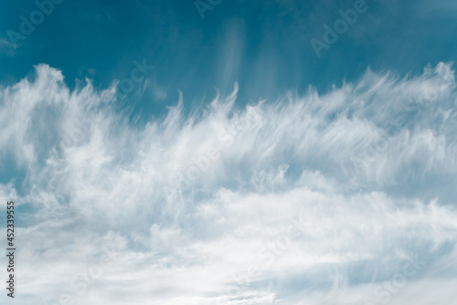 Landscape of sky and clouds view from bottom to top. Light, soft white clouds against the blue sky, windy weather. Natural background