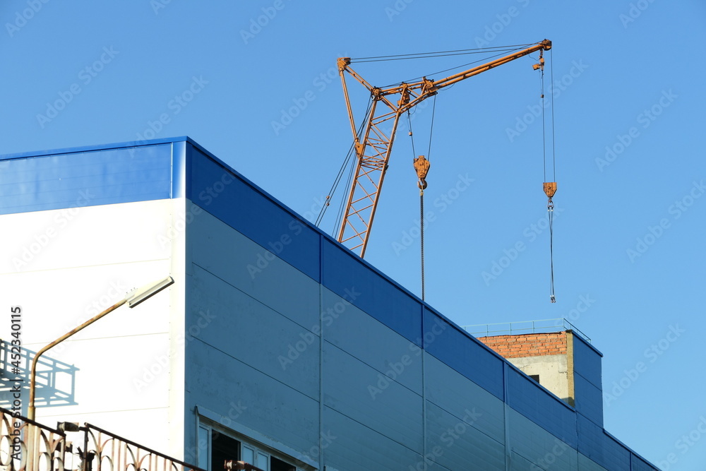 The crane works on the construction site. The crane works on the construction site.
