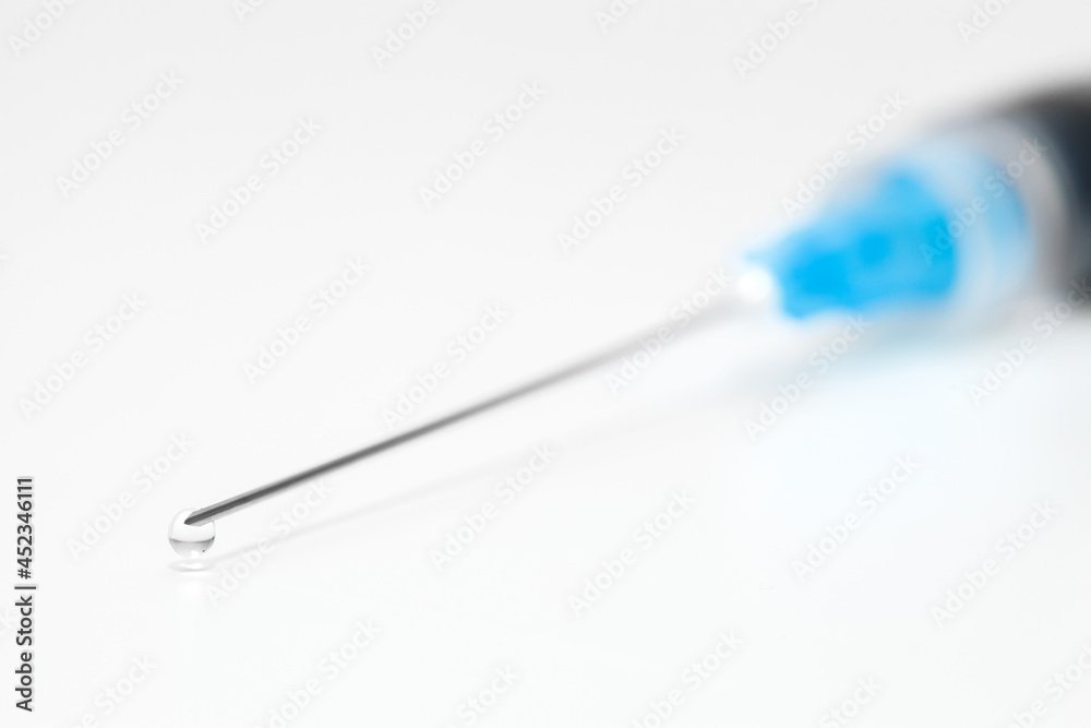 Needle сlose-up on syringe and drop of liquid medicine at end. Needle сlose-up on syringe and drop of liquid medicine at end.