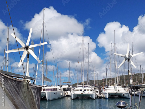 Catamarans and sailboats in the French West Indies marina. Marina in the caribbean under tropical blue sky. Close up of anemometers. Wind speed and direction meters. Boats and Navigation. photo