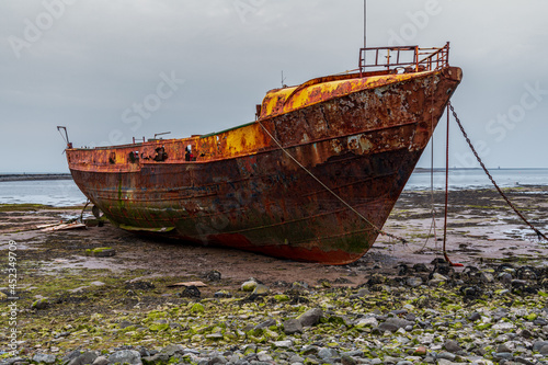 A rusty shipwreck in the mud of the Walney Channel, seen from the road to Roa Island, Cumbria, England, UK photo