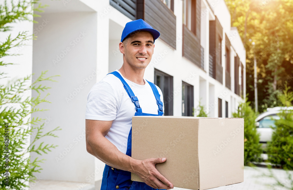 Young delivery man hold a cardboard box in his hands