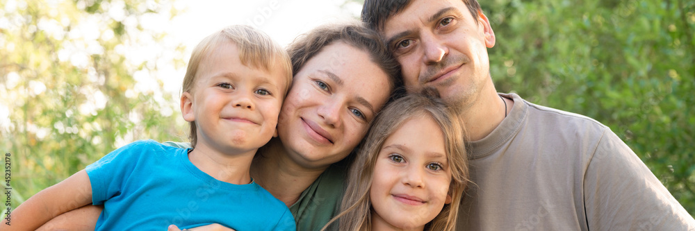 portrait of a happy family, mother and father, son and daughter, in nature outdoor in summer. banner portrait of a happy family, mother and father, son and daughter, in nature outdoor in summer. banner