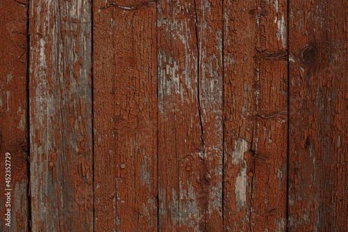 Background of textured wooden wall with brown peeling paint 
