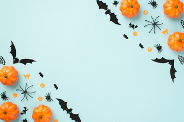 Top view photo of halloween decorations pumpkins spiders cobweb cat witch and bats silhouettes on isolated light blue background with copyspace