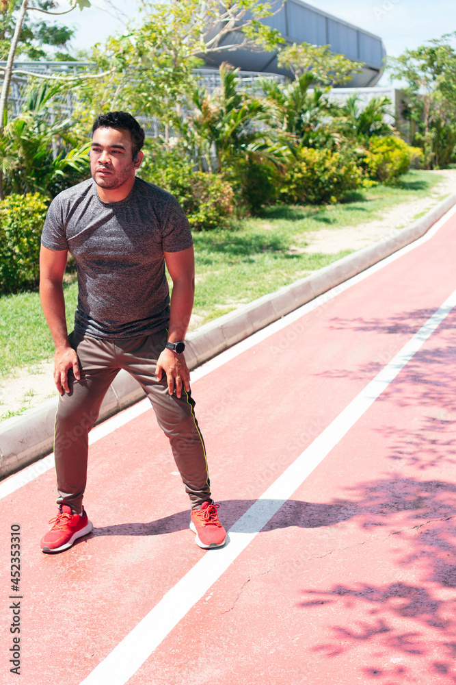 Hispanic man preparing to run in the city