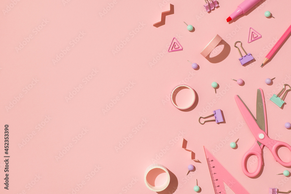 Above photo of scissors tape paper clips triangle pins pencil marker and spirals isolated on the pink backdrop with copyspace Above photo of scissors tape paper clips triangle pins pencil marker and spirals isolated on the pink backdrop with copyspace
