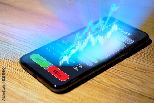 Aktienhandel auf dem Smartphone, mehr Charts und Analysen als Hologramm über dem Display, Neo-Broker, Trading, Investing, Exchange Trading, Stock Trading, Neobroker, 2021 photo