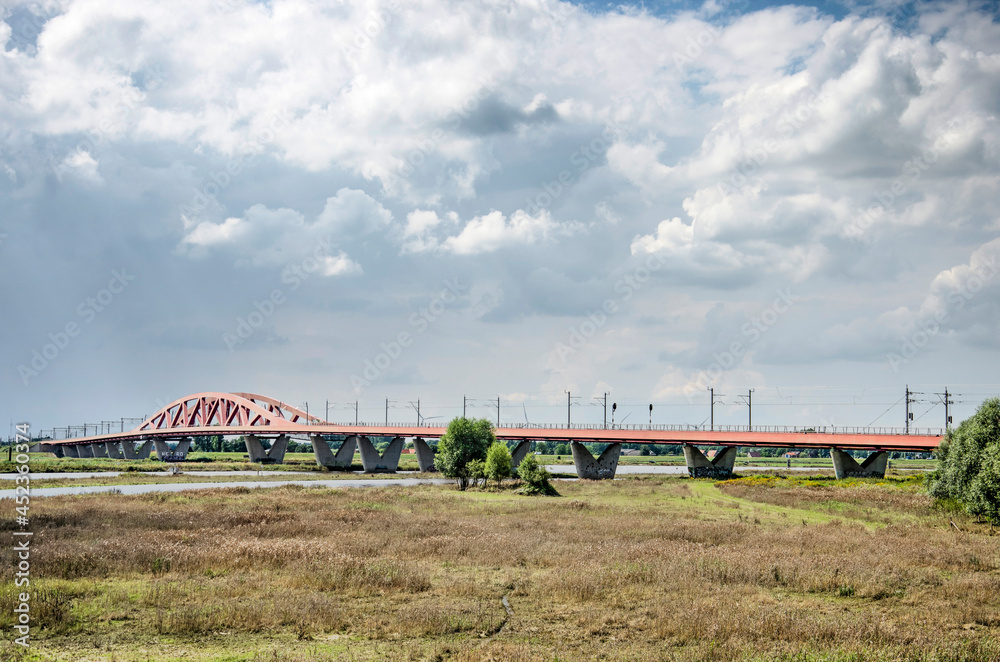 Zwolle, the Netherlands, August 4, 2021: Dramatic clouds over the IJssel river, the floodplains and the Hanzeboog railway bridge Zwolle, the Netherlands, August 4, 2021: Dramatic clouds over the IJssel river, the floodplains and the Hanzeboog railway bridge