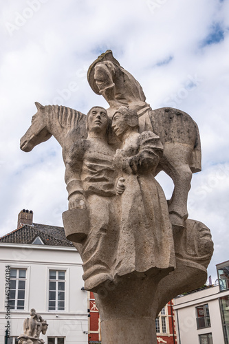 Gent, Flanders, Belgium - July 30, 2021: Closeup of white stone statue named Kwade Beth (Evil) on Brug der Keizerlijke Geneugten (Bridge of the emperors pleasures) under blue cloudscape. photo
