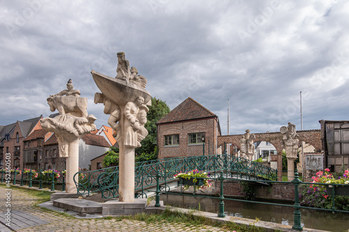 Gent, Flanders, Belgium - July 30, 2021: Brug der Keizerlijke Geneugten (Bridge of the emperors pleasures) over Lieve River, Zilverhof side across the water. Heavy gray cloudscape. photo