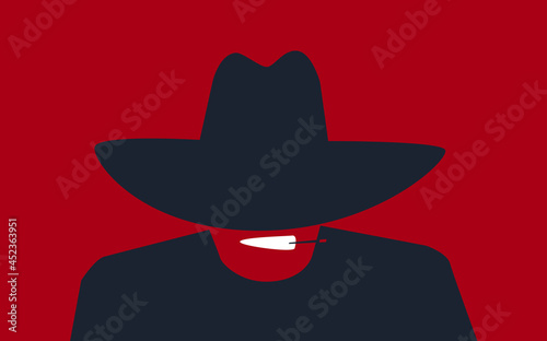 A man in a cowboy hat pulled down over his eyes smokes a cigar.