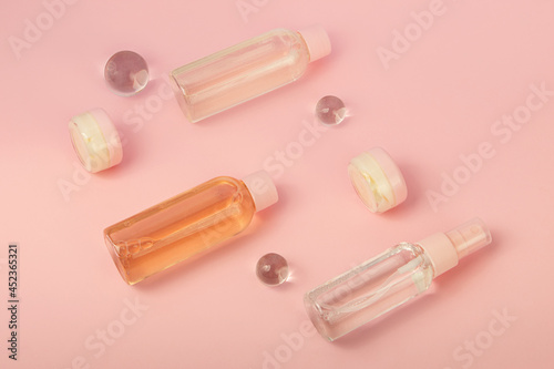 Group of cosmetics bottles with cream and liquid products. Travel kit,flat lay.Pretty pink color.
