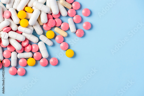 Colorful Tablets Pills and Medicine Capsules Scattererd on Background
