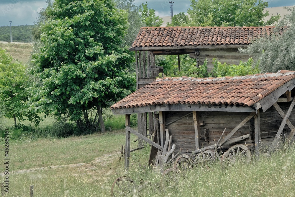 Old abandoned and brownfield village home with green grass and it is established on stone ground in nature with huge clouds background with overcast day