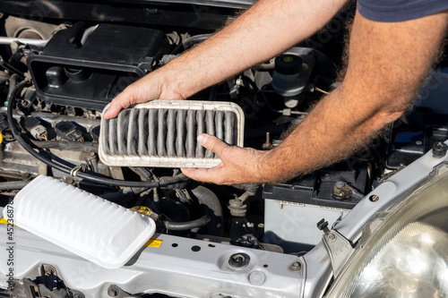 Replacing the dirty engine air filter for a car © wellphoto