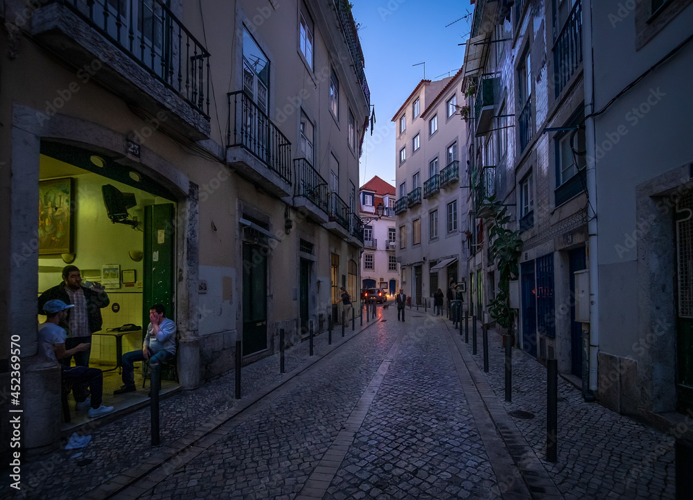 Life on the streets of the old city at sunset. Evening in the center of the old city of Lisbon. Alfama. Portugal.