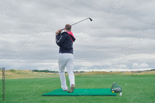 a man plays golf on a green background