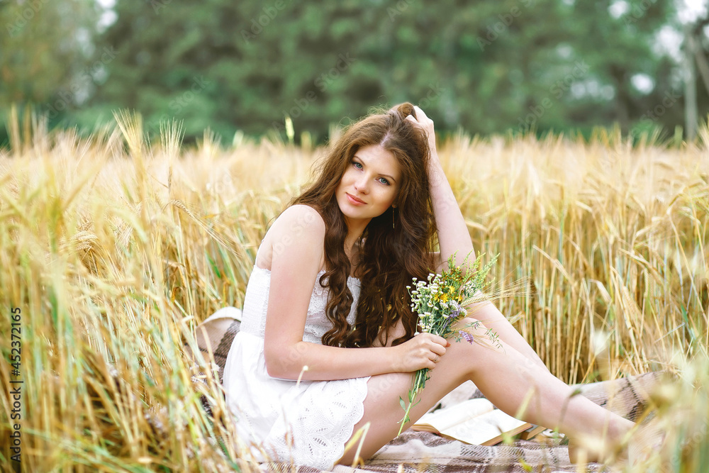 Portrait of pretty woman in summer outfit holding bouquet of flowers in field, horizontal image Portrait of pretty woman in summer outfit holding bouquet of flowers in field, horizontal image