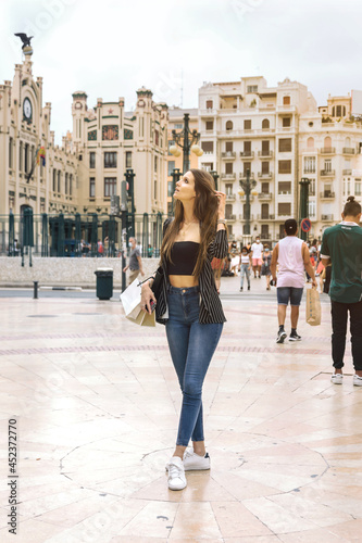 Caucasian girl tourist admires the city. Concept shopping, people, travel and cities.