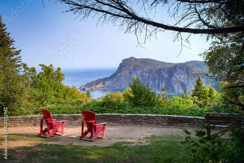 Point of view over Forillon national park at dusk, two empty adirondack chairs, Gaspésie, QC, Canada photo