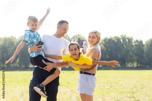 Happy family enjoying life together at meadow outdoor. © Angelov