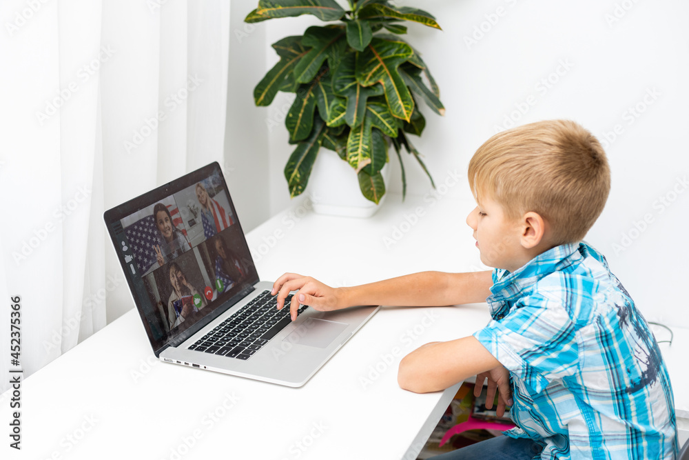 Boy video conferencing with tutor on laptop at home. Distance education concept. Boy video conferencing with tutor on laptop at home. Distance education concept.