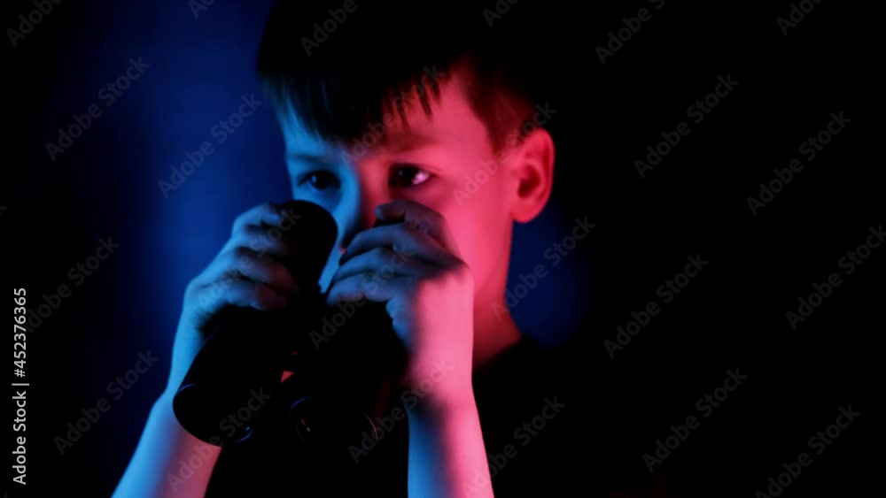 boy, guy 7-9 years old, stalker looks through black binoculars in the dark, spies, tracks down the secrets of private life, the concept of surveillance, people observation boy, guy 7-9 years old, stalker looks through black binoculars in the dark, spies, tracks down the secrets of private life, the concept of surveillance, people observation