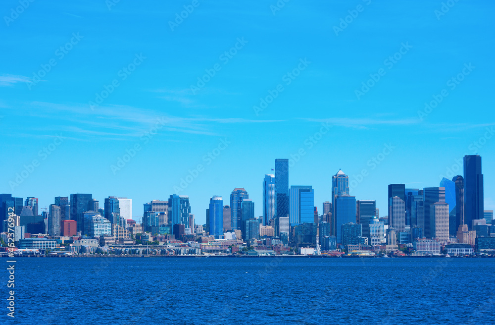 Colorful Seattle, Washington, also known as the Emerald City, skyline on a rare sunny summer morning with densely packed buildings along the Puget Sound waterfront.
