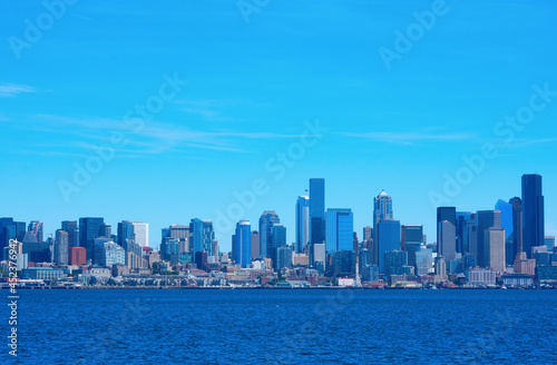 Colorful Seattle, Washington, also known as the Emerald City, skyline on a rare sunny summer morning with densely packed buildings along the Puget Sound waterfront.