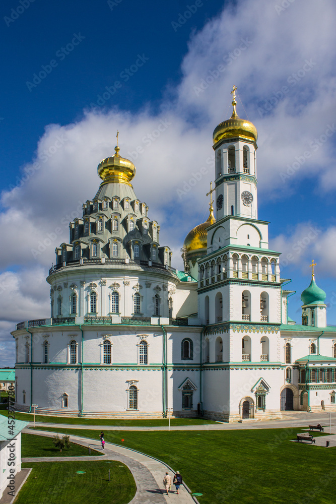 beautiful white-stone Resurrection Cathedral close-up against a blue cloudy sky on a sunny summer day in Istra Moscow region