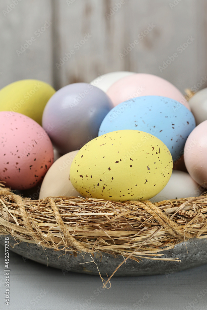 Obraz premium Bowl with Easter eggs on wooden table.