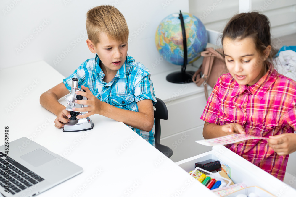 renewable energy, children, technology, science and people concept - kids or friends with laptop computer and microscope model renewable energy, children, technology, science and people concept - kids or friends with laptop computer and microscope model