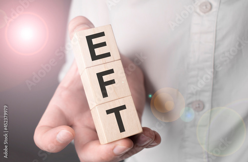 Man holding eft word on wooden cube. photo