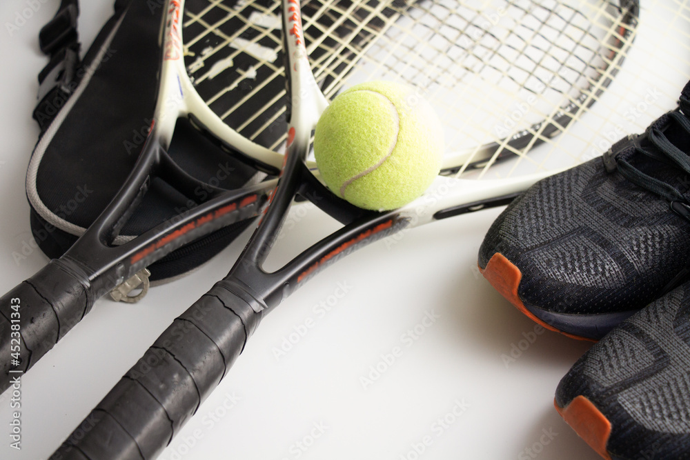 tennis racket, tennis ball and sneakers on a white background