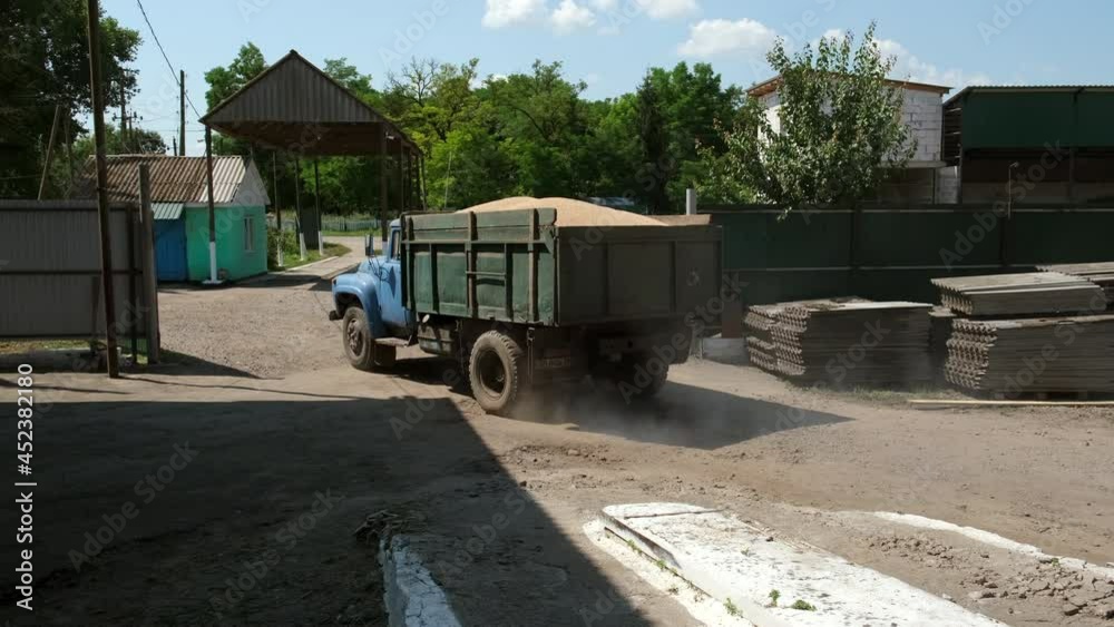 Truck carries the harvested crop, wheat to the warehouse. Slow motion. Truck carries the harvested crop, wheat to the warehouse. Slow motion.