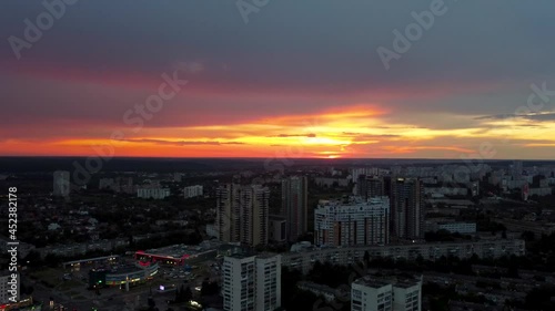 Beautiful vibrant sunset aerial view in city residential district. 23 serpnia, Pavlovo Pole, Kharkiv, Ukraine. Fly around with majestic evening skyscape, cloudscape and buildings silhouettes photo