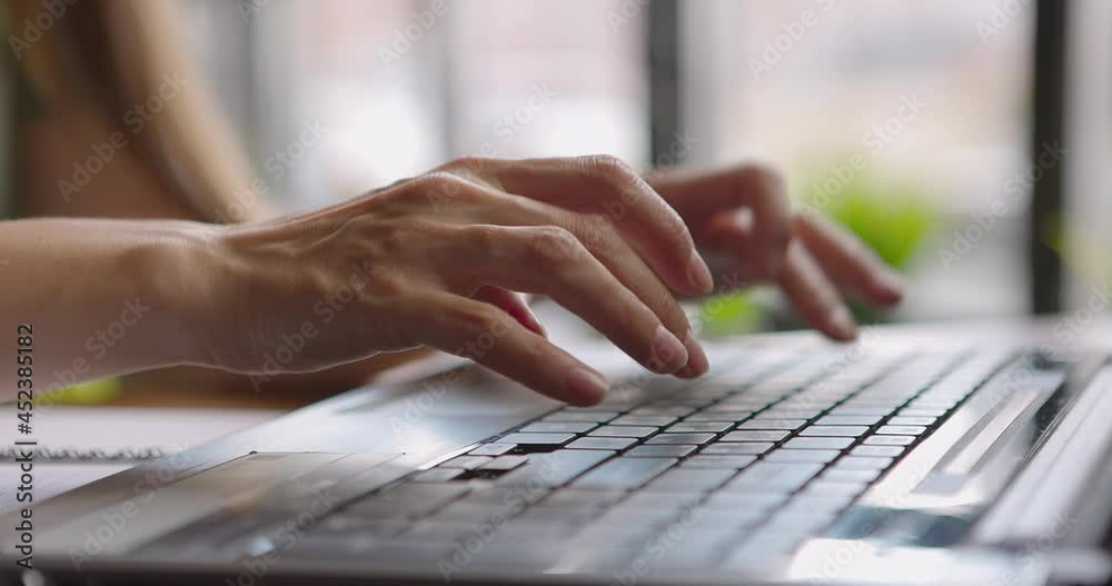 Woman's hands typing on laptop.Woman sitting in coffee shop working online using portable computer Woman's hands typing on laptop.Woman sitting in coffee shop working online using portable computer