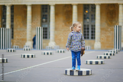 Happy cheerful girl running in Palais Royale in Paris