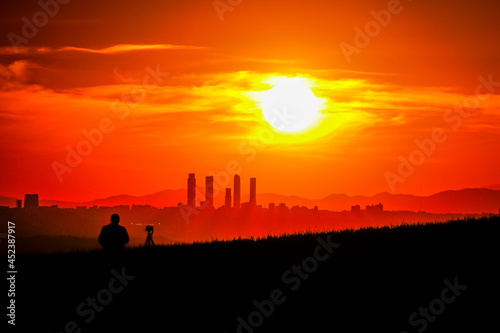 Panoramic of the area of the four towers of Madrid at sunset with the sun in the background