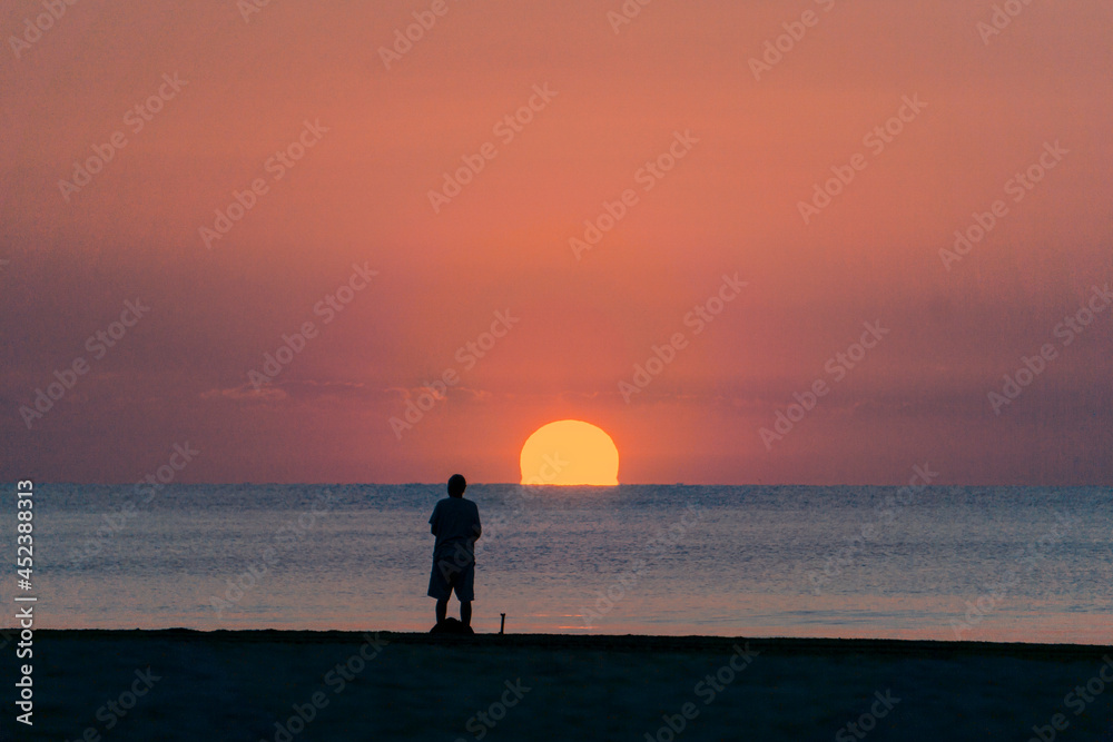 fisherman preparing fishing tackle at sunrise