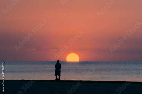 fisherman preparing fishing tackle at sunrise