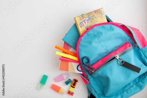 school supplies in school bag on white background