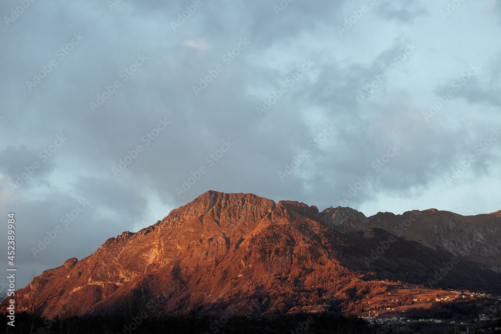 Clouds over the mountains at sunset in Alpago