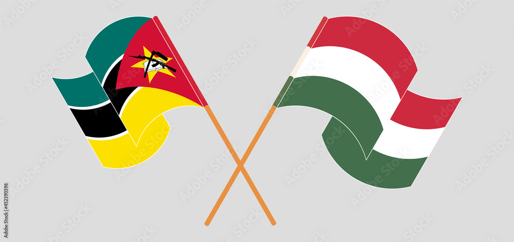 Crossed and waving flags of Mozambique and Hungary Crossed and waving flags of Mozambique and Hungary