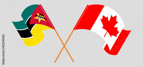 Crossed and waving flags of Mozambique and Canada