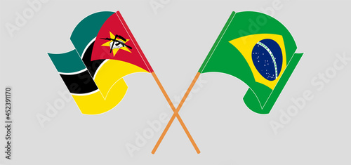 Crossed and waving flags of Mozambique and Brazil