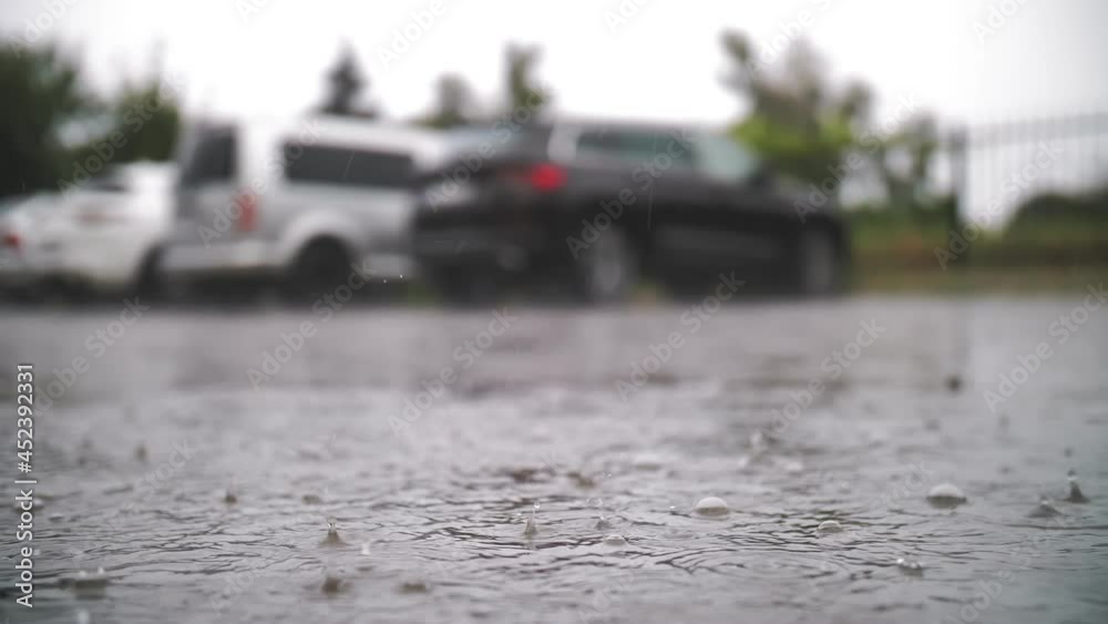rain, puddles. raining on parking lot. close-up. raindrops fall into puddles with splashes and bubbles during a rainstorm. summer showers. rain, puddles. raining on parking lot. close-up. raindrops fall into puddles with splashes and bubbles during a rainstorm. summer showers.